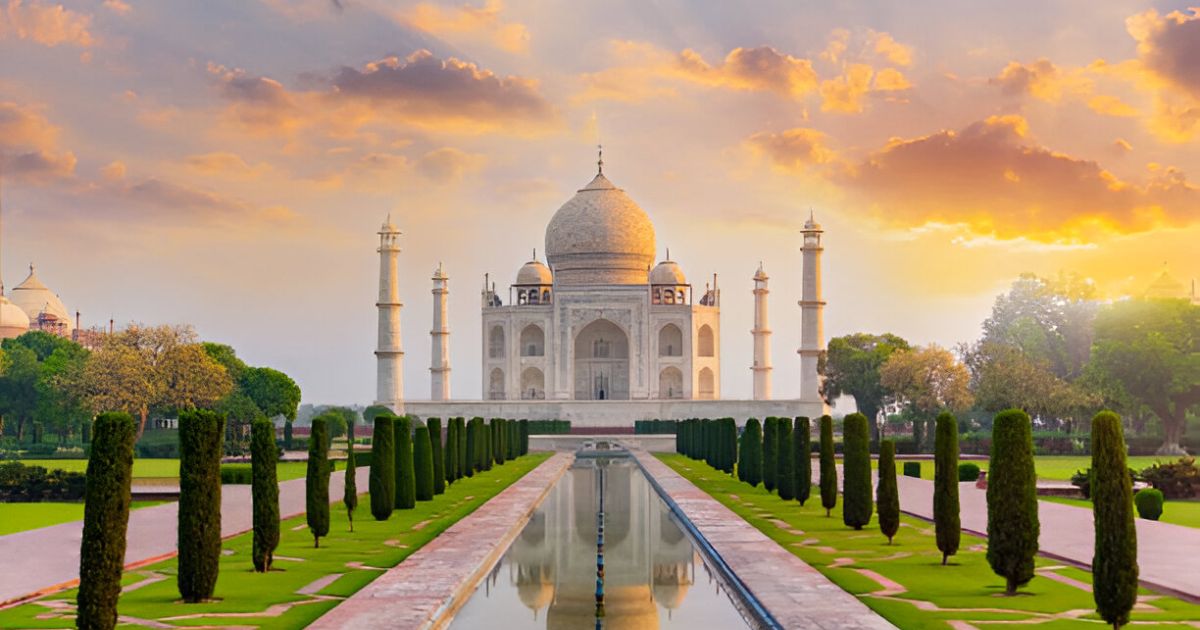 Taj Mahal at sunrise with golden sky and reflecting pool, captured during photography tour in Agra.