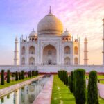 Taj Mahal at sunrise with colorful sky and reflecting pool, captured during Taj Mahal Photography Tour in Agra.
