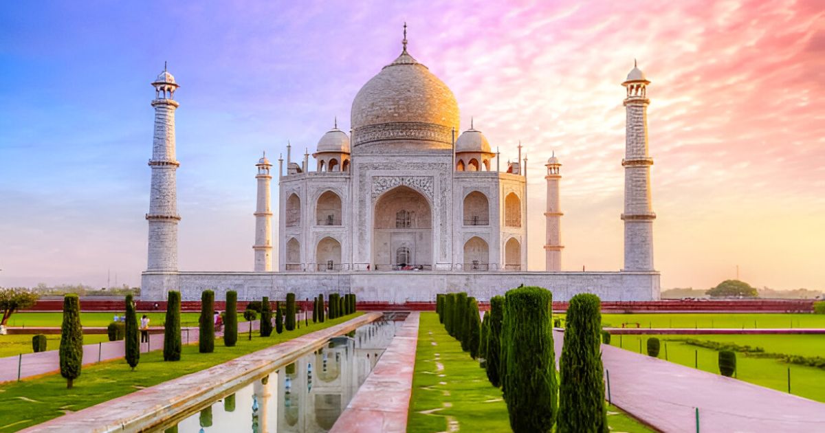 Taj Mahal at sunrise with colorful sky and reflecting pool, captured during Taj Mahal Photography Tour in Agra.